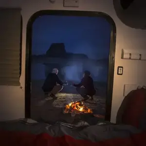looking out at the campfire from inside a Bean RV