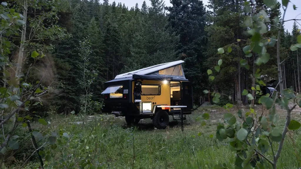 A Bean Squared trailer set up in the middle of a field at twilight.