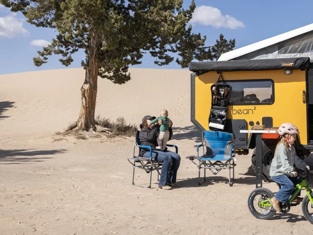 A family at camp beside a Bean Squared