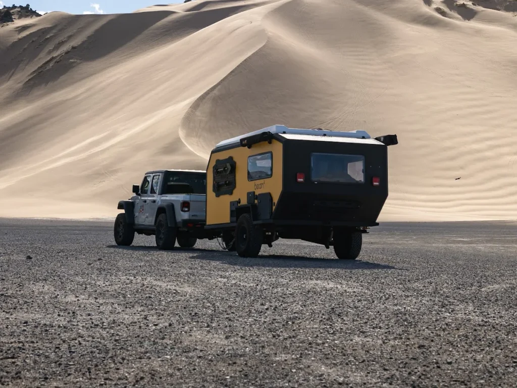 Bean Squared towed behind a Jeep below the dunes