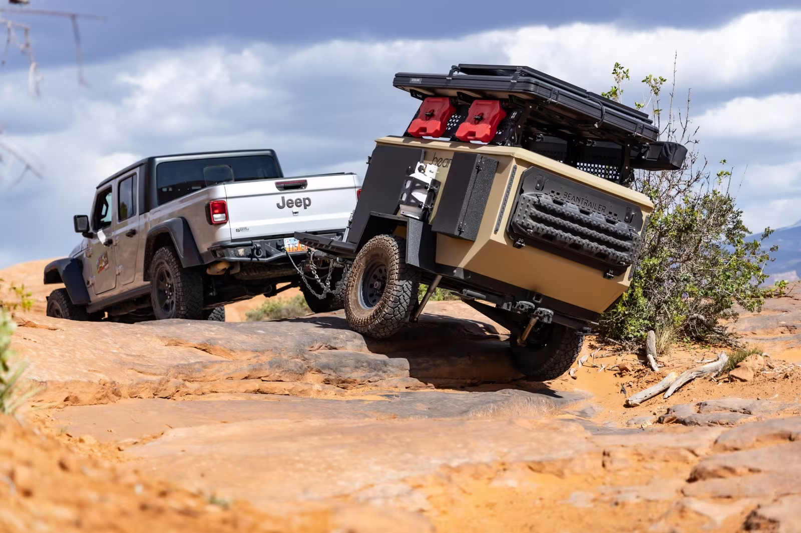 Jeep Gladiator towing a Bean Pod off road teardrop trailer up a slickrock climb