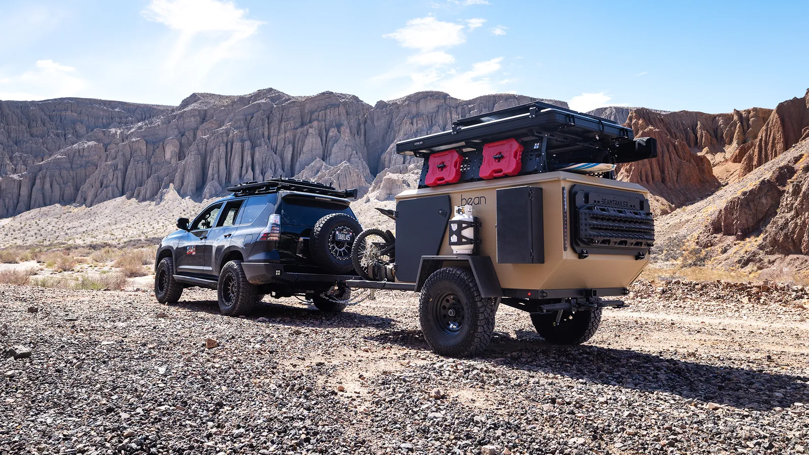 Bean Pod loaded with gear behind a 4Runner in a rocky desert canyon