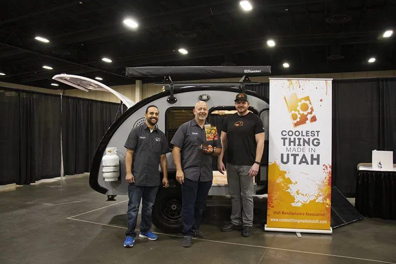 Three Bean team members beside a Bean at the Utah Manufacturers Association Coolest Thing Made in Utah stand